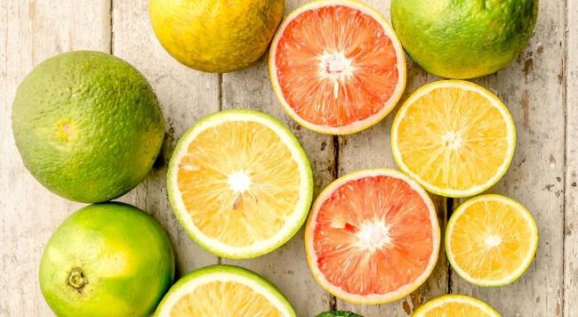 variety of citrus fruits, both whole and cut in half